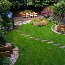 Garden Thumbnail size Amazing Exterior Concept Design For Garden Back Home With Several Planting Green Grass Small Stone Best Fence And Wooden Sitting Areas With Wooden Table And WHite Chair For Inspiring