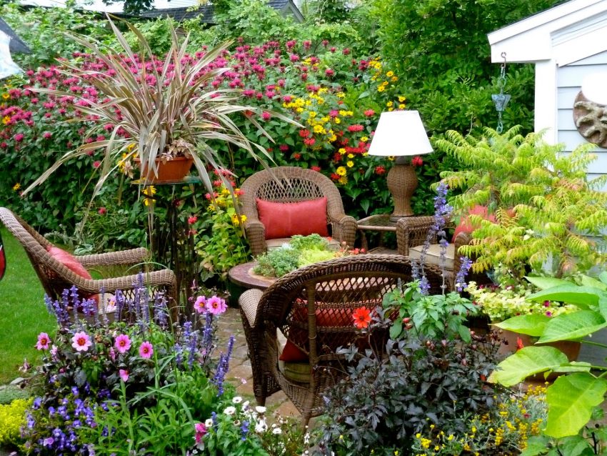 Garden Awesome Garden For Small House With Various Flower Growth With Pink Red Yellow Purple And Many Beauty Color Lamp Sitting Area With Rattan Chair And Wooden Table Designing Garden for Small House