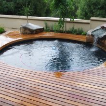 Pool Design Thumbnail size Cool Design Ideas With Varnished Wooden Deck Round Shape Green Plant And Grass Cute Small Waterfall Amazing Stone And Style Of Fence For Outdoor Pool