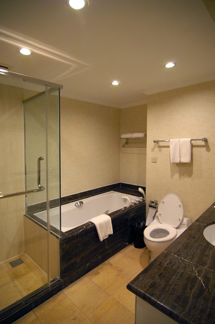 Bathroom Eye Catching Clear Glass Frameless Walk In Shower Dark Gray Granite Countertop Vanities Feat White Square Tub In Modern Hotel Bathroom Plan Soothing Hotel Scheme Simple Thing to Getting the Most Out of Decorating a Deluxe Bathroom