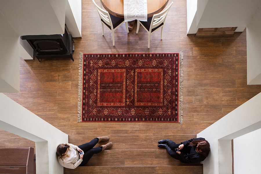 Double Height Center Interior With Concrete Pillar Coring Brown Patterned Rug Upon Wooden Floor Architecture