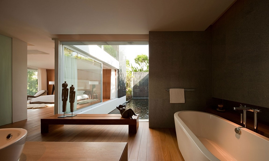 Awesome Bathroom Design With Long Oval White Bathtub Before Wooden Bench Splashed With Large Glassy Window Villa & Resort