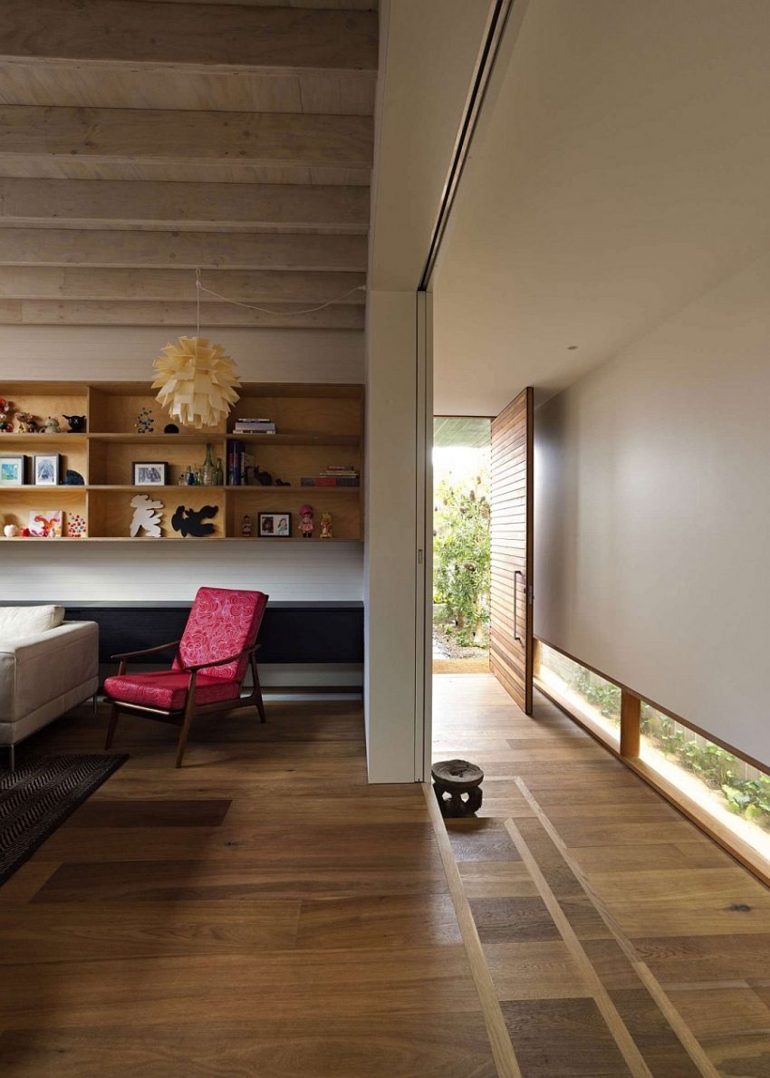 Ideas Creative Wall Shelving Idea With Pink Chair Aside Upon Wooden Floor And Narrow Glassy Ventilation Family House with a Lot of Ventilations but Still Maintaining Privacy