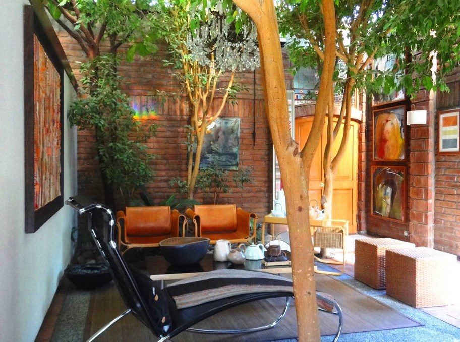 Outdoor Relaxing Spot With Black Leather Metal Reclining Chairs Beneath Maple Tree Before Artistic Paintings Interior Design